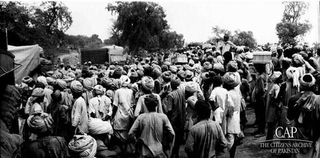 refugees-carry-their-belongings-alongside-a-train-track.jpg