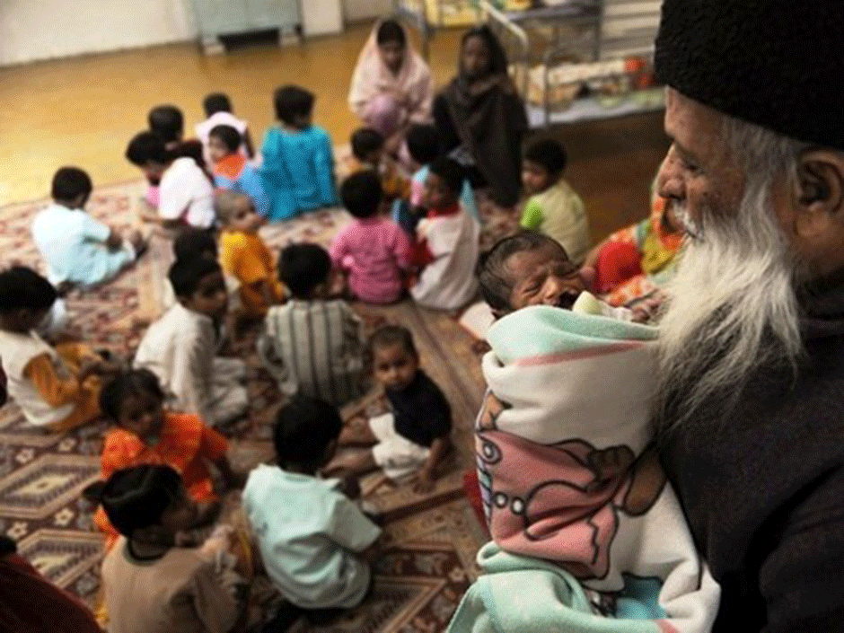 Abdul Sattar Edhi holding a Newborn