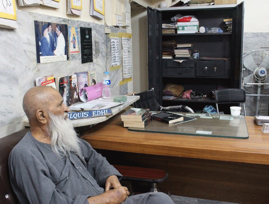 Edhi looks toward an empty cupboard from which money was stolen